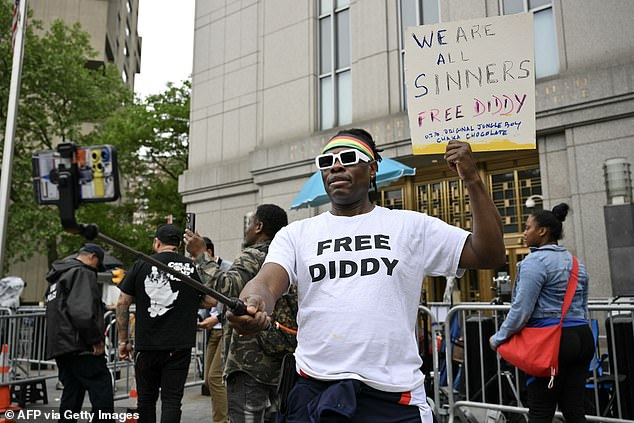 A Sean "Diddy" Combs' fan holds a sign outside federal court during the trial