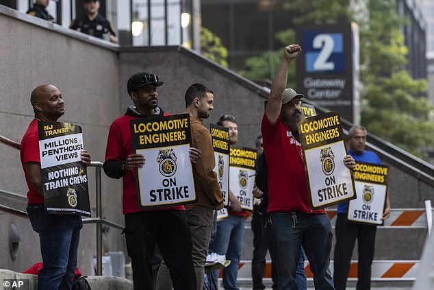 Roughly 450 unionized locomotive engineers walked off the job at midnight, shutting down the New Jersey Transit's rail network. Pictured are union members at the picket line in Newark