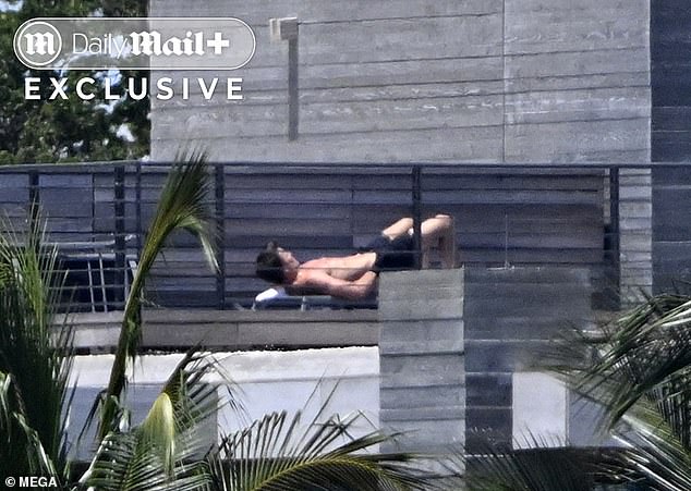 Brady strategically covers part of his body as he attempts an even tanline
