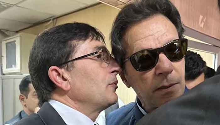 PTI Chairman Barrister Gohar Ali Khan whispers in PTI Founder Imran Khans during his appearance before a court. — X@BarristerGohar/File