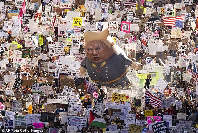 Thousands of protesters hold signs and flags and a large balloon with an image of President Donald Trump during the nationwide 'Hands Off!' protest against Trump and his advisor, Tesla CEO Elon Musk, in downtown Los Angeles on April 5, 2025