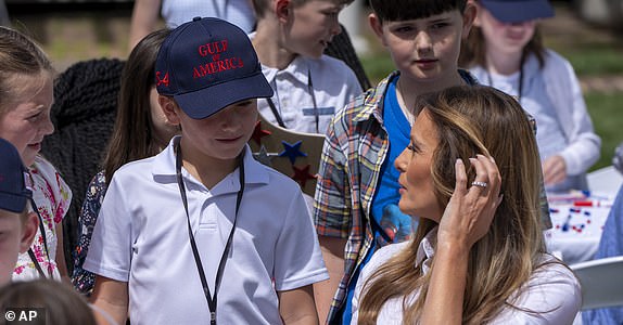 First lady Melania Trump looks at a decorated flag as she participates in flag decorating during a Take Our Child to Work Day event in the Jacqueline Kennedy Garden at the White House, Tuesday, May 20, 2025, in Washington. (AP Photo/Alex Brandon)