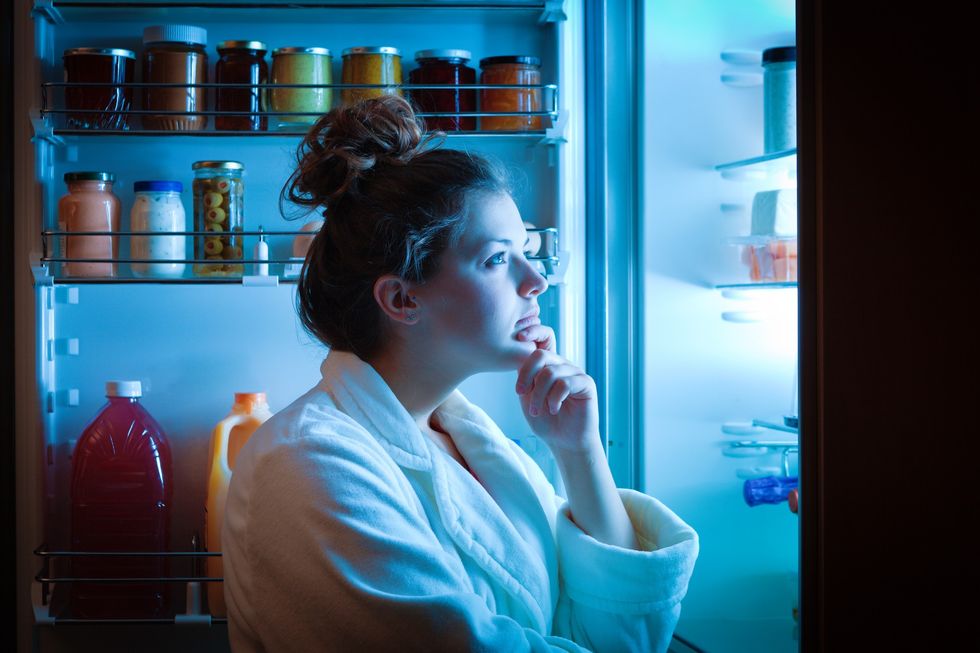 Woman going to the fridge at night