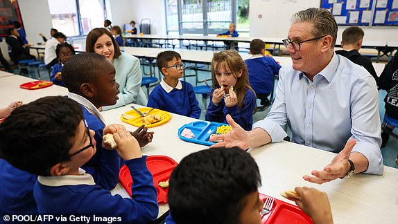 Britain's Prime Minister Keir Starmer (R) and Britain's Education Secretary Bridget Phillipson (L) speak with pupils over lunch during a visit to a primary school in Essex, eastern England, on June 5, 2025. The UK Government announced Thursday that over half a million more children are to get free school meals. (Photo by Isabel Infantes / POOL / AFP) (Photo by ISABEL INFANTES/POOL/AFP via Getty Images)
