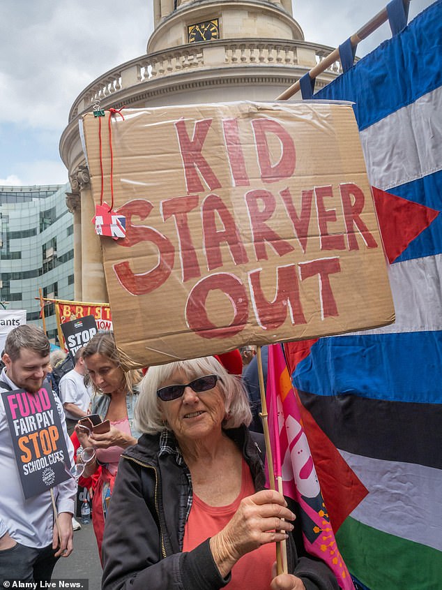 A women protests against Labour's economic policies while holding a sign saying 'Kid Starver out'