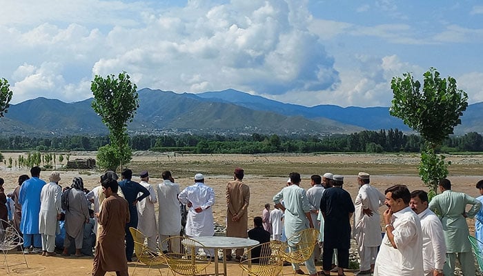 Residents gather, after tourists, who were on a picnic, were swept away by overflowing floodwaters in the Swat River, in Swat Valley, on June 27, 2025. — Reuters