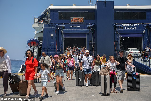 Cruisecritic, a Tripadvisor company, says that up to seven cruise ships can dock simultaneously on the island, which means that they could bring over 14,000 passengers if at full capacity (Pictured: tourists disembark from a boat in Santorini on July 20, 2024)