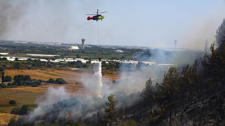A firefighting helicopter drops water to extinguish a wildfire in the Aksu district of Antalya.
Pic: Reuters