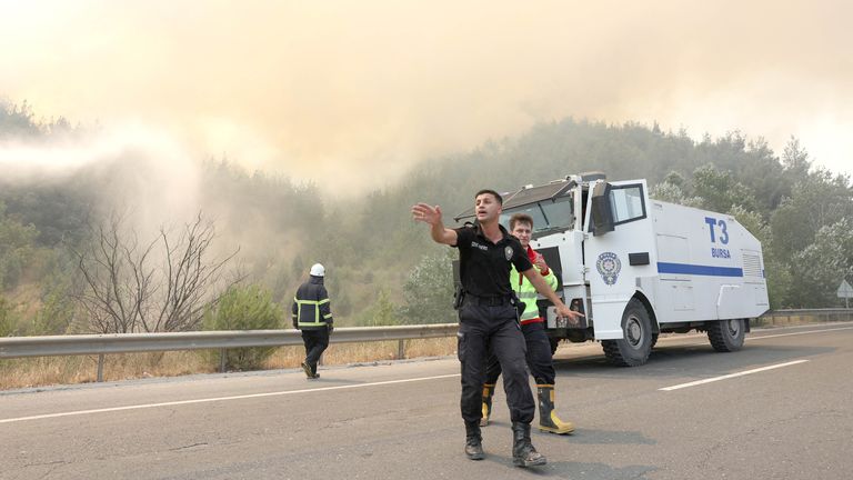A police officer clears the area ahead of the arrival of firefighters during a wildfire near Osmanel, Turkey
Pic: Reuters