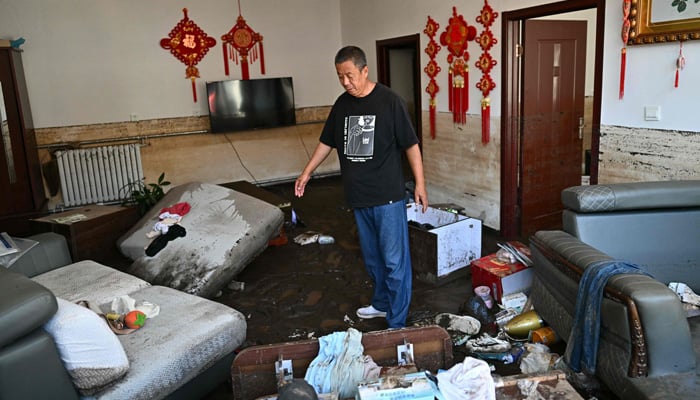 A man shows his flood-damaged house after the recent heavy rains in Huairou district, on the outskirts of Beijing, on July 30, 2025. — AFP
