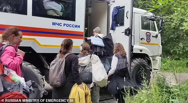The heightened risk could last from two months to two years, as the quake’s impact on underground pressure and magma movement may take time to spark an eruption. Pictured are people in Russia piling into an emergency vehicle on Wednesday