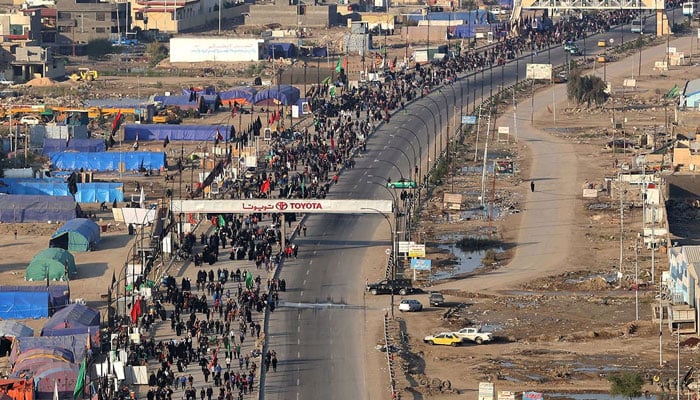 Iraqi and Iranian pilgrims walk in the central Iraqi city of Najaf toward Karbala, to take part in the Arbaeen religious festival, on September 11, 2022. — AFP