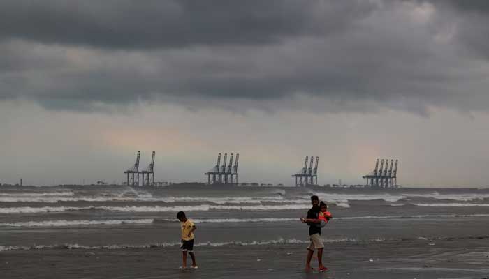 Children play, with the rainbow and rain clouds in the background at Clifton Beach in Karachi, Pakistan August 30, 2024. — Reuters