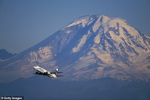 Mount Rainier (pictured behind a commercial airplane) has experienced over 1,000 earthquakes since July 8, one of the biggest swarms recorded