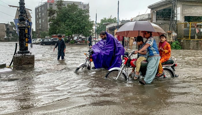 Commuters drive across flooded Dhok Khabba Road following heavy rain in Rawalpindi on July 17, 2025. — APP