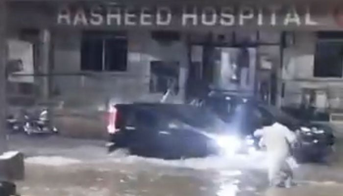 The image shows a road in Lahore submerged in rainwater as traffic passes through on July 16, 2025. — X@iamfahadsb/Screenshot