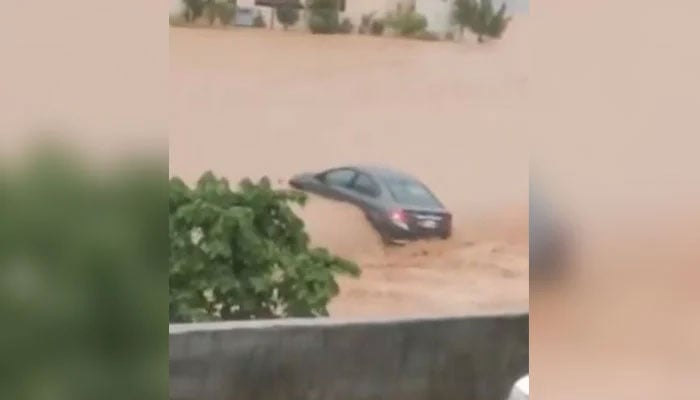 A car is being swept away into a storm drain after heavy rains in Islamabad on July 22, 2025. — Screengrab via Geo News