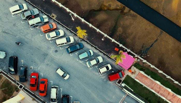 Representational image shows cars parked alongside a road. — Pexels