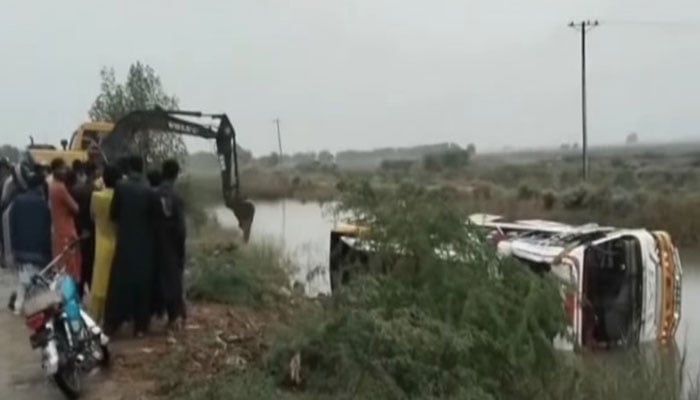 An excavator busy in rescue operation to recover the overturned bus on National Highway. — Screengrab via Geo News