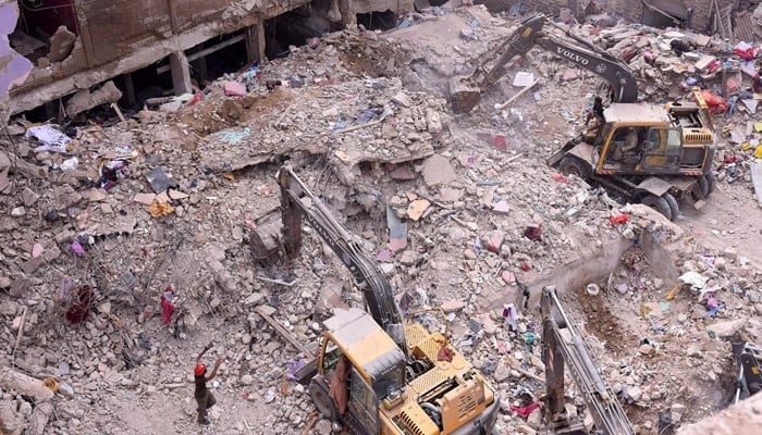 Rescue workers busy in operation at the collapsed building site in Baghdadi, Lyari, as more bodies are recovered from the debris. — APP/File
