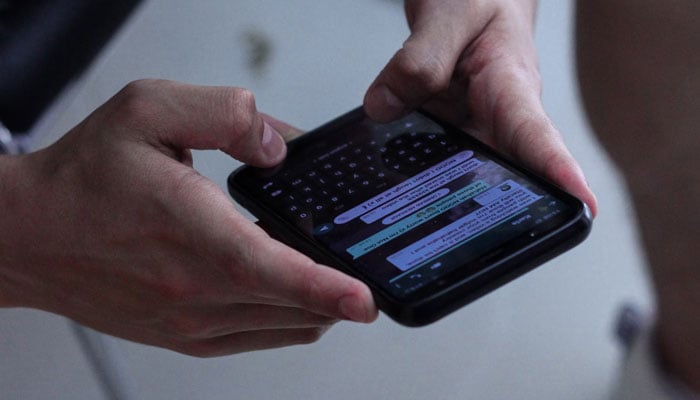 This representational image shows a person texting via WhatsApp. — Unsplash