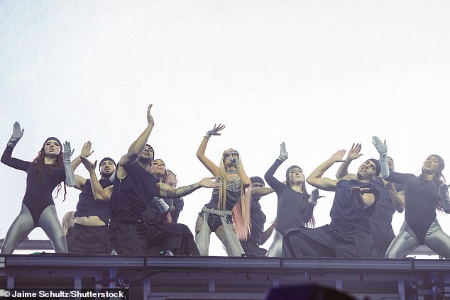 The racy leather number was studded with silver chains and beads, whilst the star finished off her noughties look with fingerless gloves, fishnet tights and tinted shades