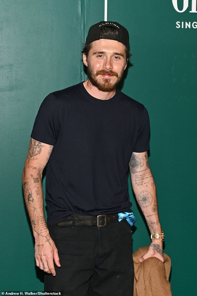 He cut a casual figure in a black T-shirt and baseball cap with jeans
