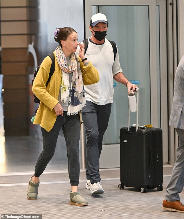 Hugh trailed slightly behind Sutton as he juggled a water bottle and luggage