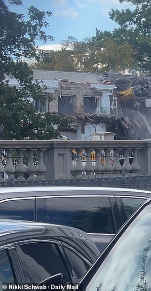 Banging and crashing was heard throughout the area as clusters of staffers and journalists watched construction vehicles tearing lumps out of the walls