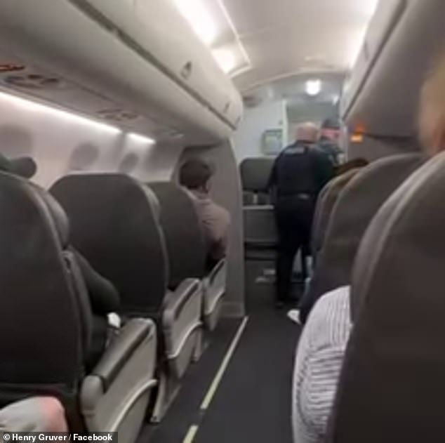 Police officers board the plane after the pilots returned to the airport amid fears of a hijacking