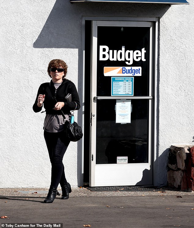 Ashlee walking out of the Budget rental office after she struck out on her chance to rent a car - partially due to being pursued through court over a string of unpaid credit card debts