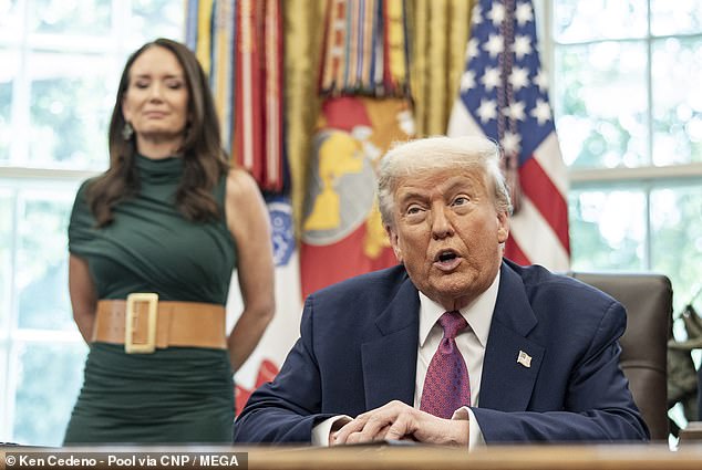 Agriculture Secretary Brooke Rollins stands behind Trump as he speaks in the Oval Office