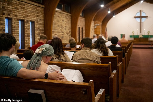 Christianity has been on a steady decline in the US for the past two decades, and is set to be a minority religion by 2070 if it continues at the current pace (Pictured: A prayer service at Gloria Dei Lutheran Church in Michigan)