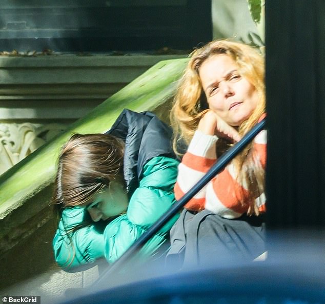 Katie Holmes', 46, daughter Suri, 19, appeared notably downcast while sitting on a doorstep in New York on Wednesday