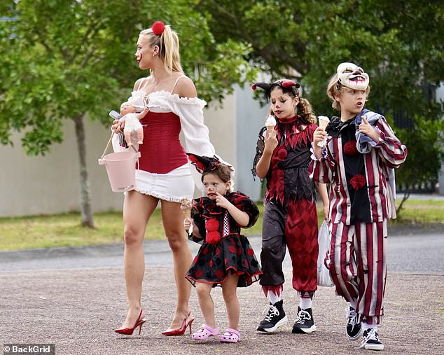 The 31-year-old (far left) could be seen wearing a red corset over a white mini-dress as she took to the streets with Wolf (far right), Saskia (second from right) and Posy (second from left)
