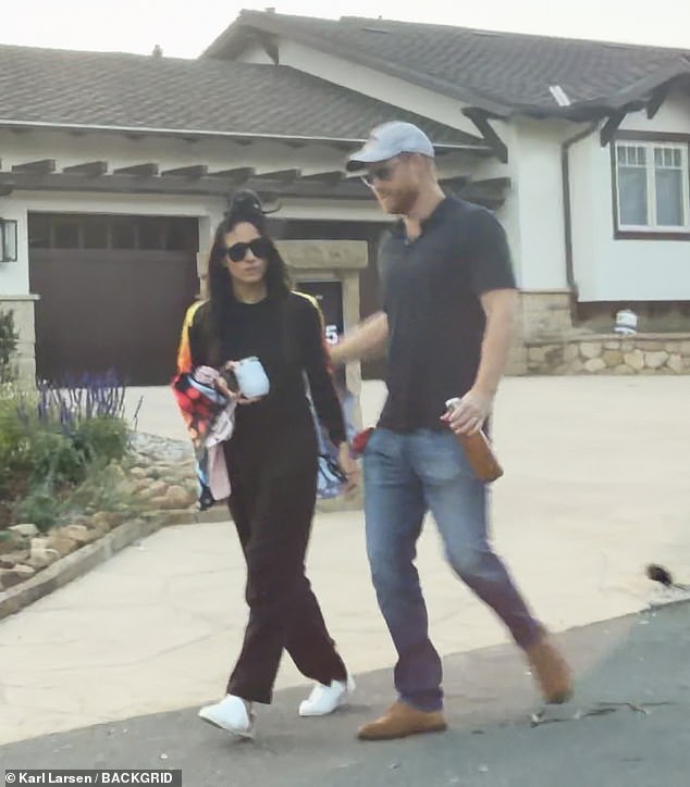 Meghan sported sunglasses and a black tracksuit with her butterfly wings while Harry opted for a casual look consisting of a light blue cap, navy shirt and jeans