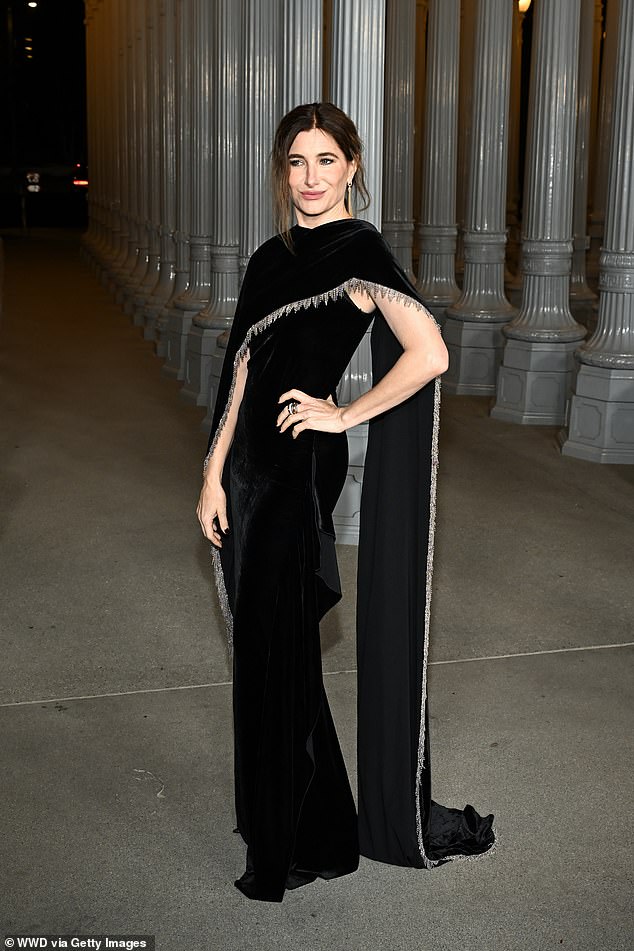 Kathryn Han put on a tasteful display in a black sleeveless dress with a long black tasseled cape dragging behind her