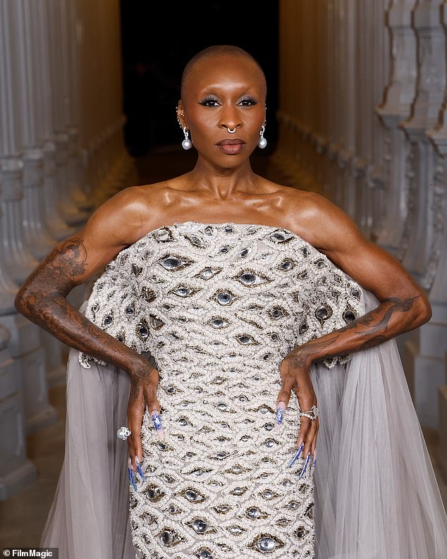 The dress featured a gray tulle train fanned out behind her, and she wore silver heels with the look