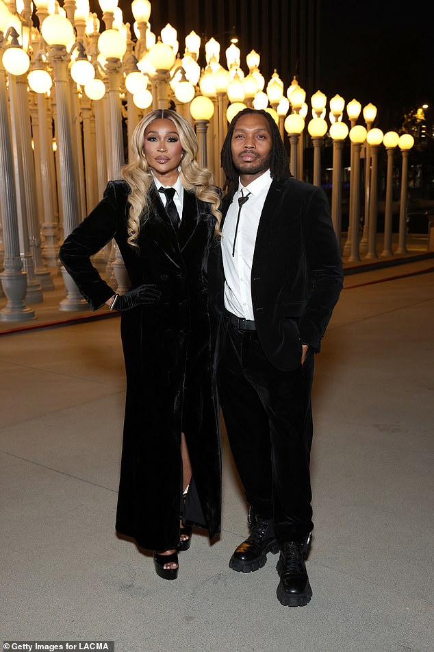 The Real Housewives Of Atlanta star Cynthia Bailey in a dark velvet suit dress. She was joined by Francis Roberts in a velvet tux with a black Prada bolo tie and chunky boots