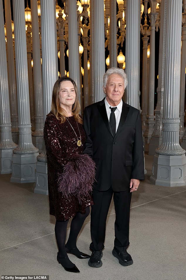 Dustin Hoffman wore a black suit with his black necktie askew, and he dress it down with black athletic shoes. His wife Lisa wore a sparkling purple sequined dress with feather embellishments