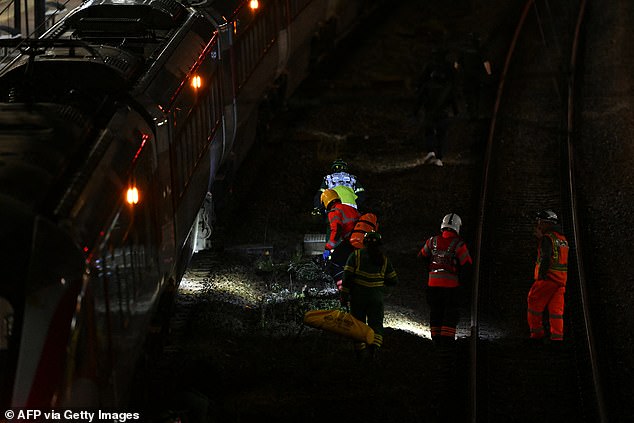 In the hours after the attack, forensic officers could be seen apparently searching for clues on the track at the side of the train which still had its lights on