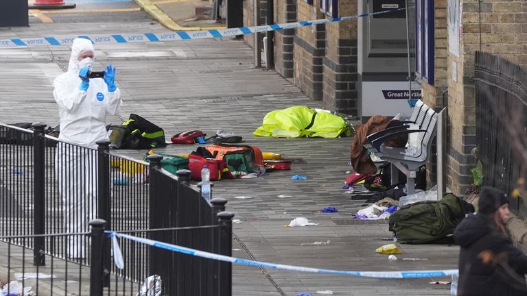 Investigators examine the scene outside Huntingdon station. Pic: PA