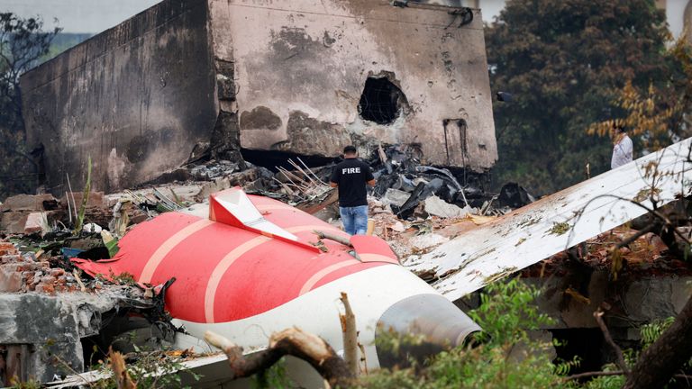 A fire officer stands next to the crashed aircraft. Pic: Reuters