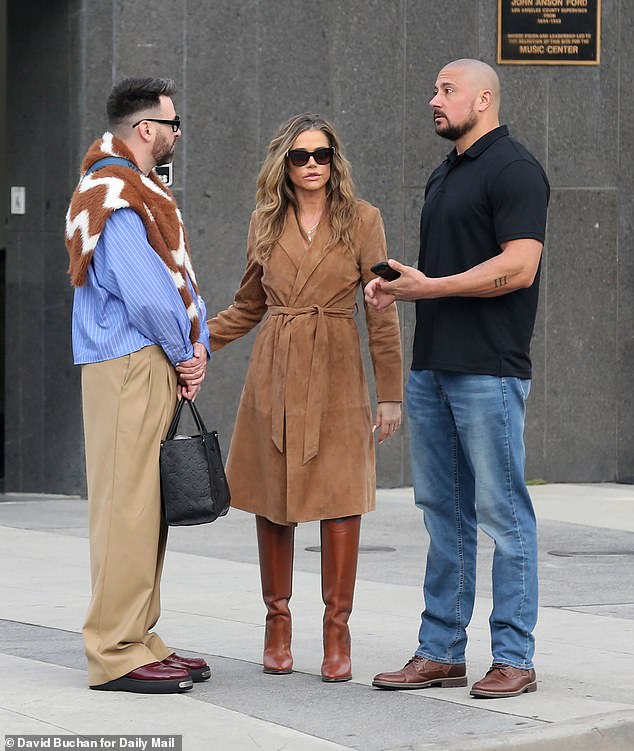 Richards appeared at the hearing in downtown LA looking stylish in a camel trench coat,  pants, and knee-high brown heeled boots. She was accompanied by a burly, tattooed bodyguard