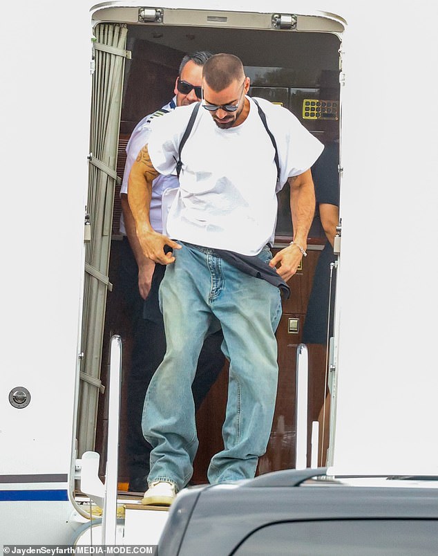 With a shock of facial hair and dark sunglasses Ricky looked almost unrecognisable as he disembarked from the plane