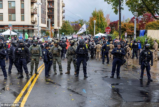 Federal officers line up as people take part in a protest organized by Portland Contra Deportaciones, at the city's ICE facility on October 25, 2025