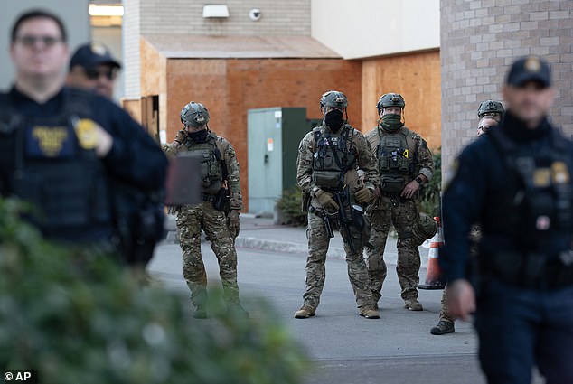 Law enforcement officers stand guard near the United States Immigration and Customs Enforcement (ICE) facility in Portland on October 21, 2025