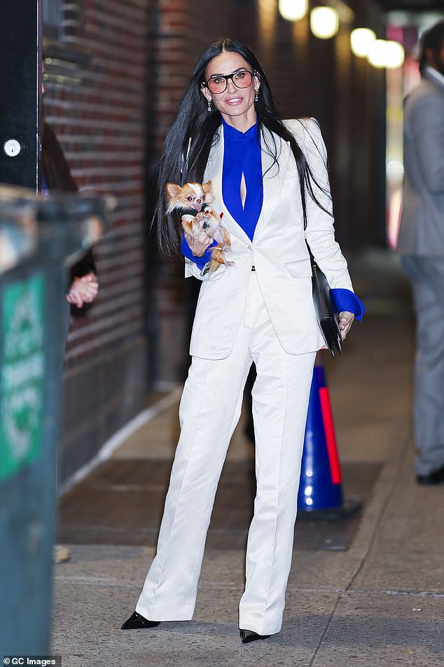 The actress, 63, put on a radiant display in a fitted satin blazer and matching white trousers, over an electric blue blouse with a racy keyhole cutout