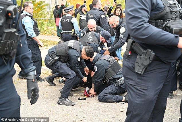Police officers are seen forcing a protestor to the ground as they make an arrest