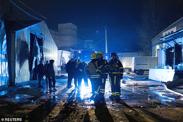 Firefighters stand at an impact site after a Russian drone attack, amid Russia's attack on Ukraine, in Kyiv, Ukraine, on November 8, 2025